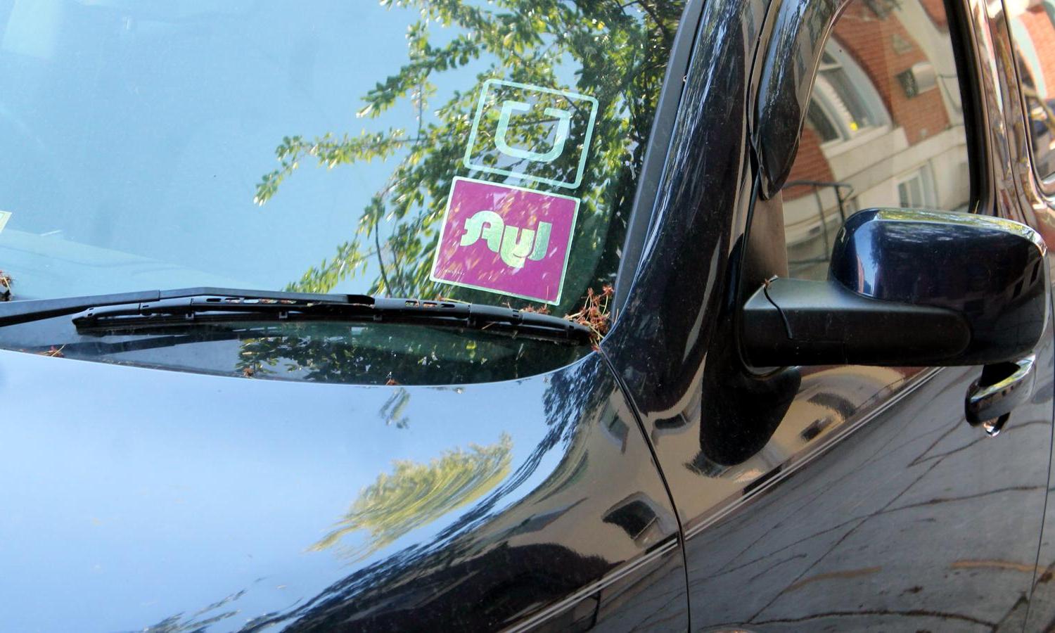 Uber and Lyft stickers in a car window