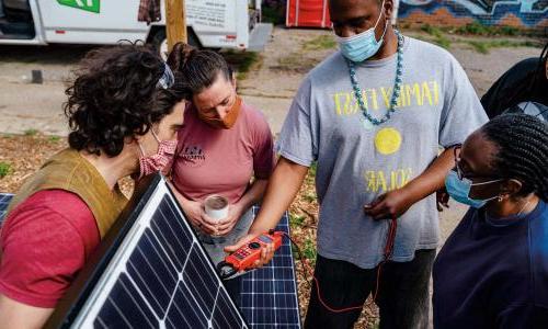高地公园社区居民检查太阳能电池板.