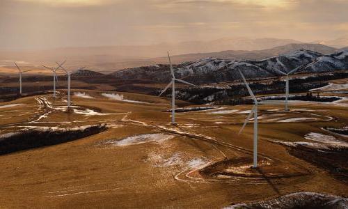 wind turbines on top of snowy desert mountains
